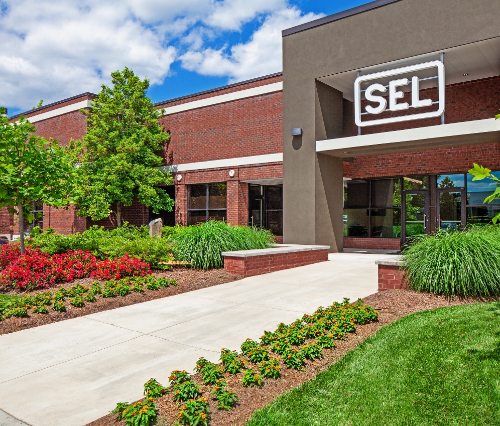 Front of modern brick office building with lush landscaping