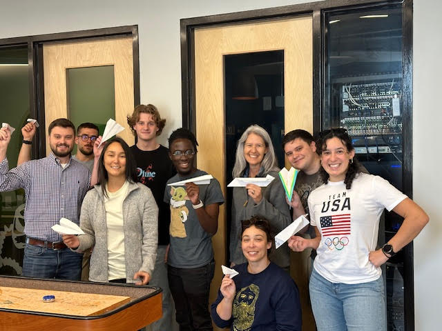 Orsborn Design Group team holding paper airplanes in office